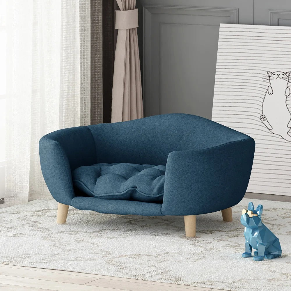 Blue pet bed in a room with a painting and curtains