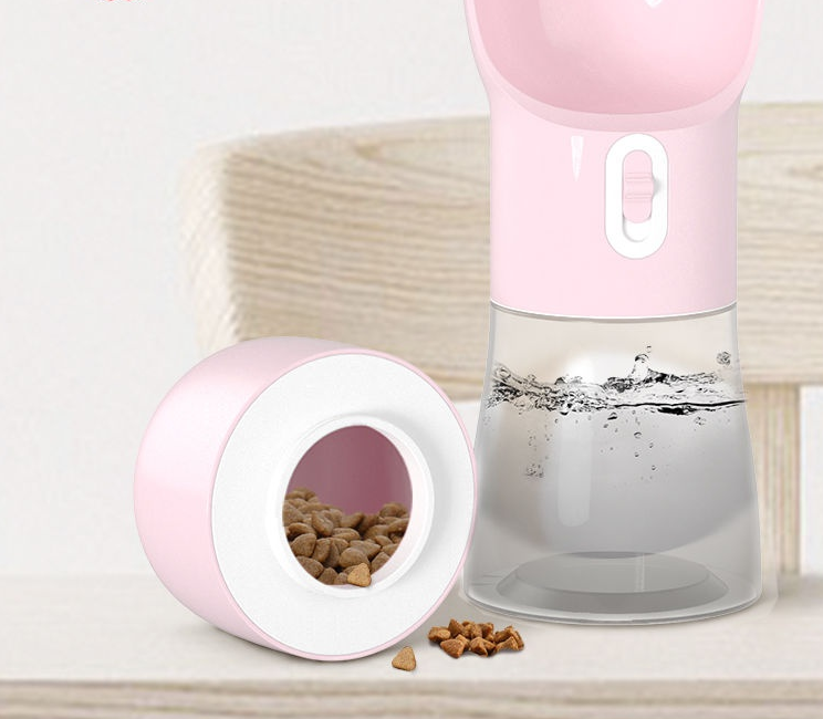 Pink pet water bottle and food container on a light wooden surface with a white background