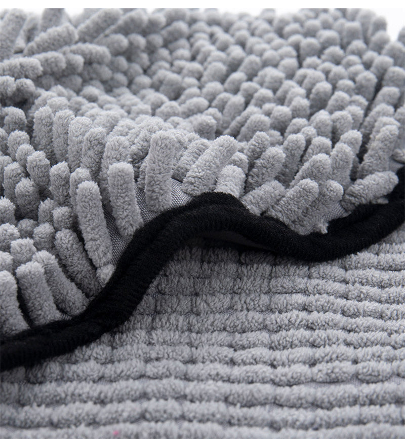 Close-up of a textured gray rug with a black border